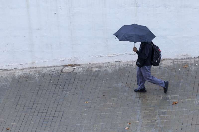 Un joven se protege de la lluvia con un paraguas. EFEKai FrsterlingArchivo
