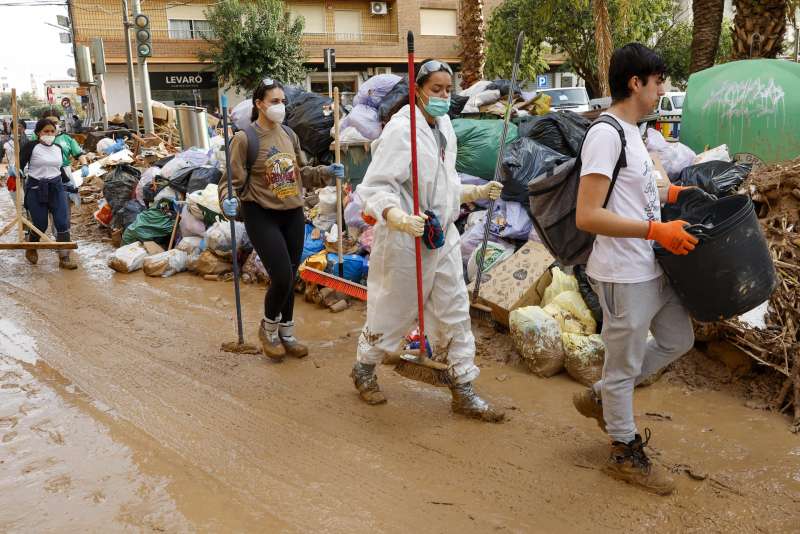 Un grupo de voluntarios participa en las labores de limpieza de las calles de Catarroja, una de las localidades ms afectadas por las inundaciones. EFE Chema Moya
