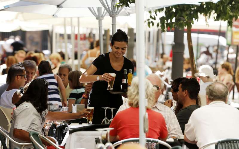 Una camarera trabaja en una terraza del centro de la ciudad de Valencia llena de turistas. EFEKai Frsterling