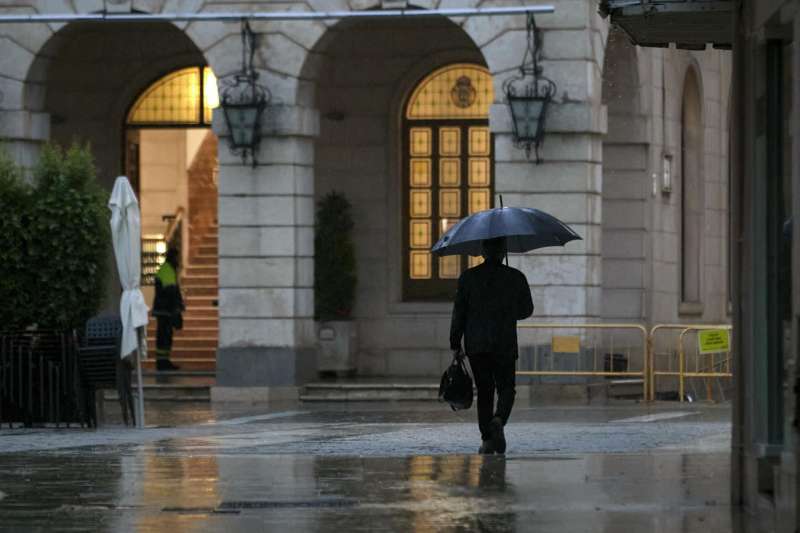 Una persona se protege de la lluvia con un paraguas. EFENatxo Francs