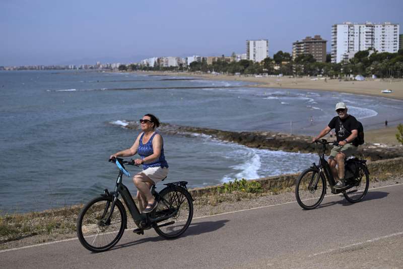 Dos personas pasean en bicicleta por la costa de Benicssim. EFEAndreu Esteban
