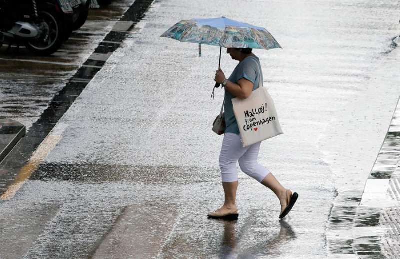 Una persona se protege de la lluvia. EPDA
