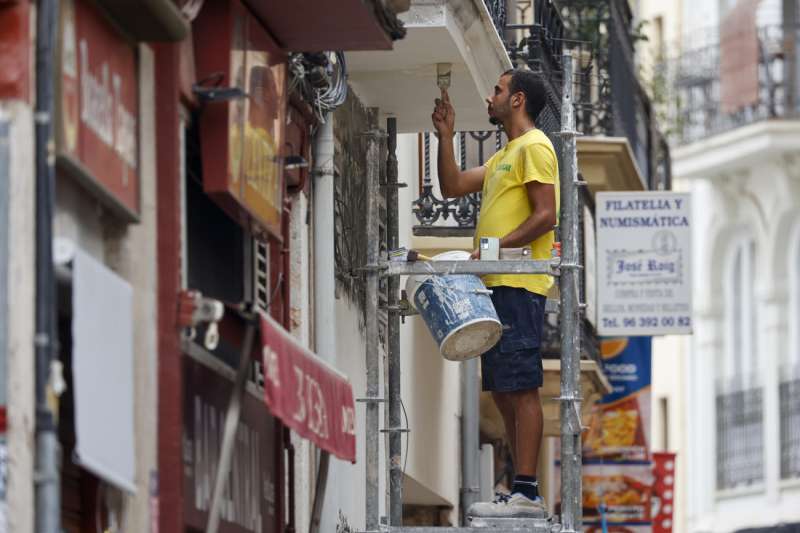 Un pintor trabaja en una cntrica calle de Valencia. EFEBiel Alio
