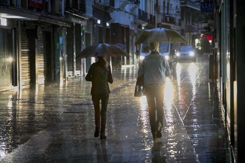 Dos personas se protegen de la lluvia(AEMET). EFENatxo Francs
