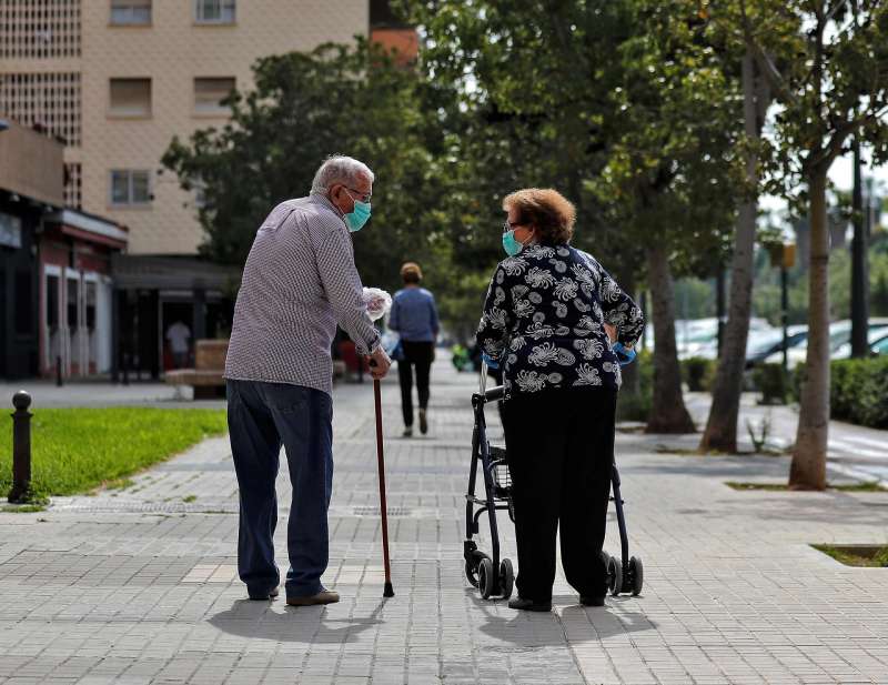 Dos personas mayores conversan mientras pasean. EFEManuel BruqueArchivo
