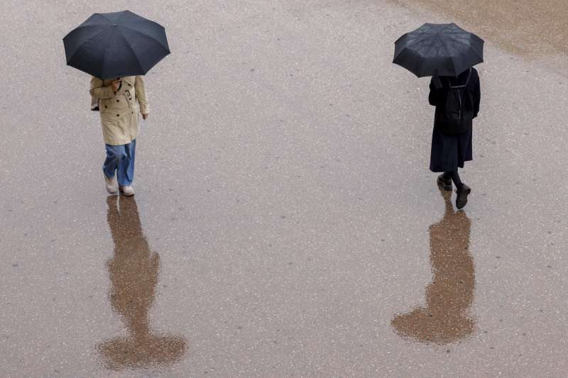 Dos personas se protegen de la lluvia con un paraguas. EFE/Ana Escobar/Archivo