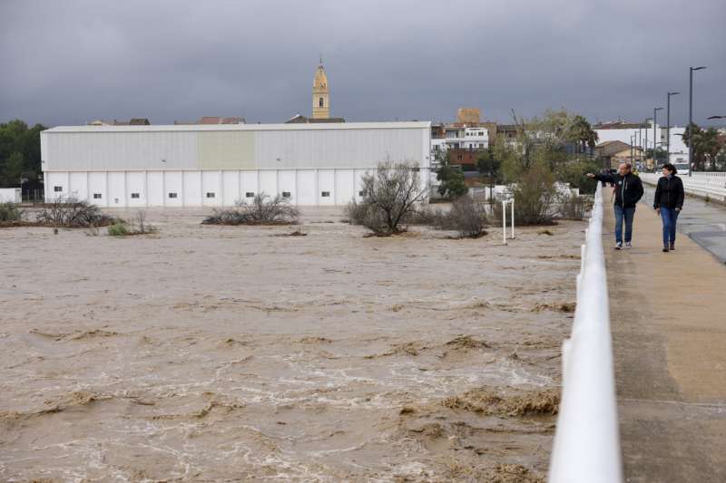 Dos personas contemplan el gran caudal del ro Magre a su paso por Alfarp debido a las lluvias torrenciales. EFEAna Escobar
