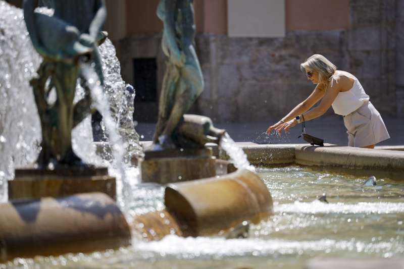 Una mujer se refresca en una fuente. EFE/Biel Aliño
