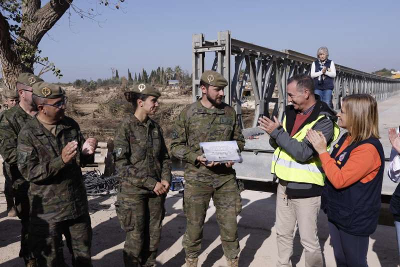 La delegada del gobierno Pilar Bernab y el alcalde de Riba-roja de Tria, Robert Raga les entregan a los militares una placa durante un acto simblico por la construccin de un puente nuevo . EFE Kai Forsterling
