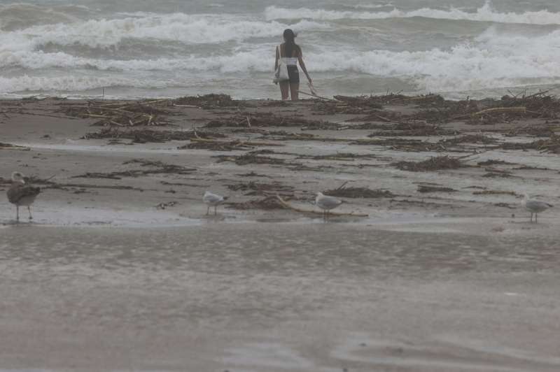 Una joven contempla el mar en la playa de la Malvarrosa en una da lluvioso. EFEAna Escobar
