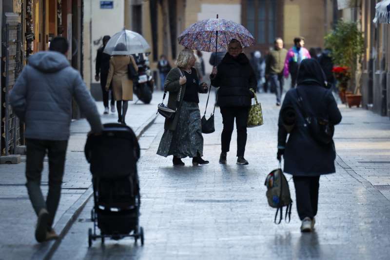 Varias personas se protegen con paraguas de la lluvia en Valncia. EFEBiel Alio
