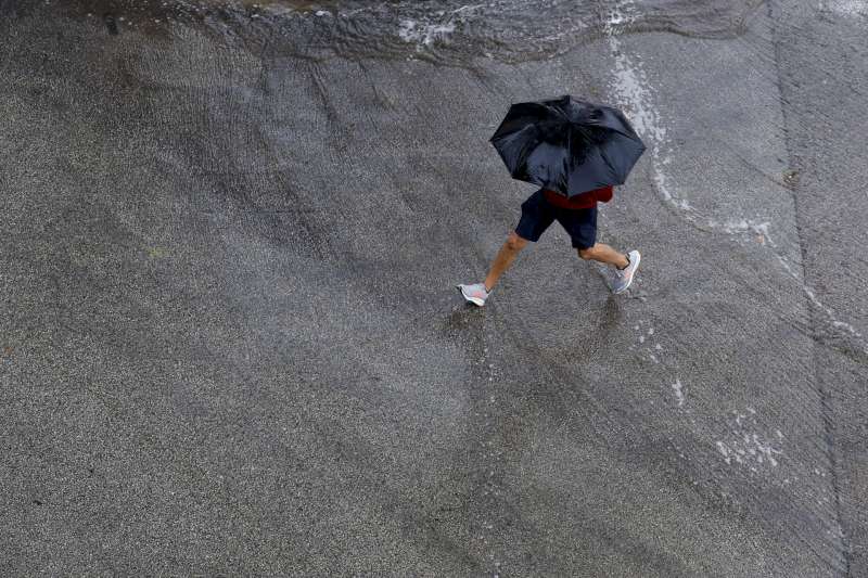 Una persona se protege de la lluvia en una jornada de chubascos y tormentas en la Comunitat Valenciana, que este lunes afectarn sobre todo al tercio norte. EFEKai FrsterlingArchivo
